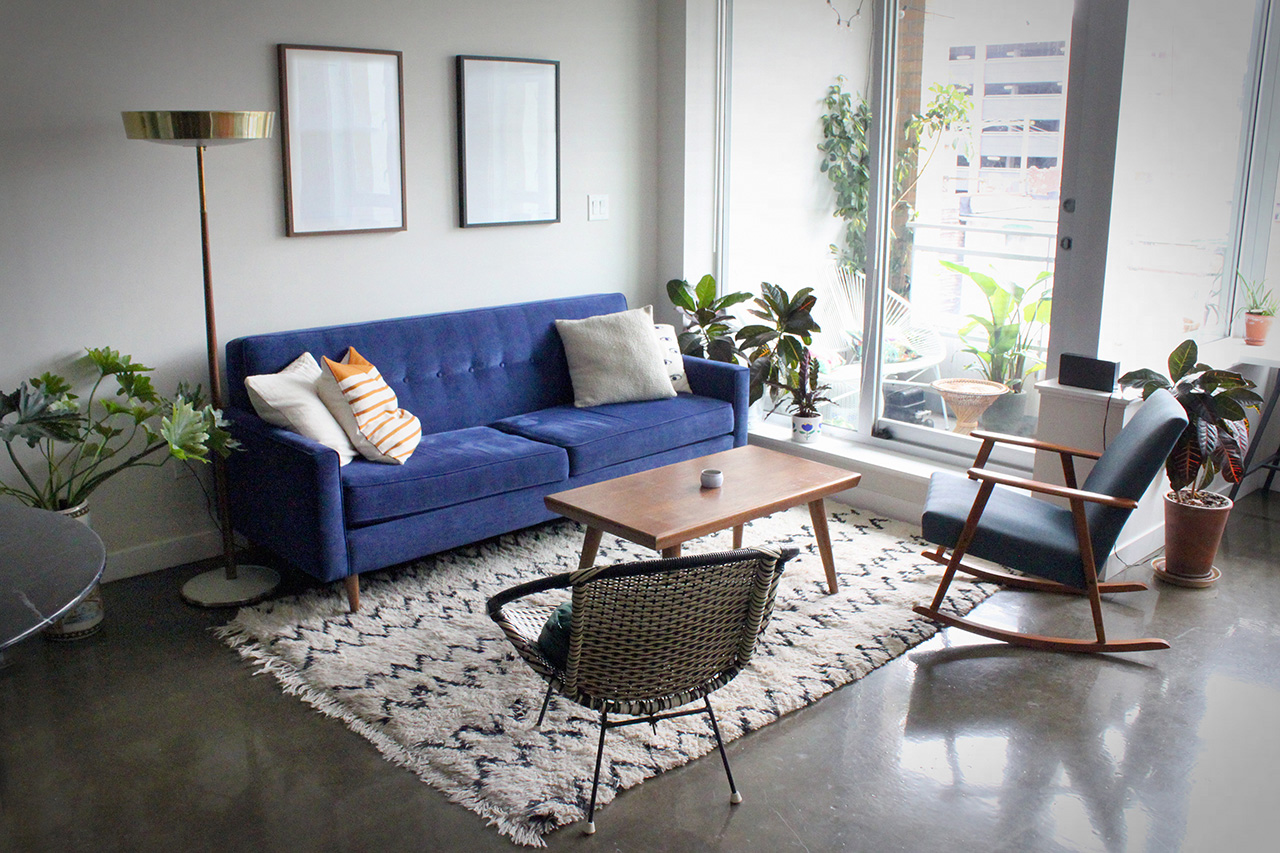 Stylish living room interior with trendy sofa with pillows, real photo